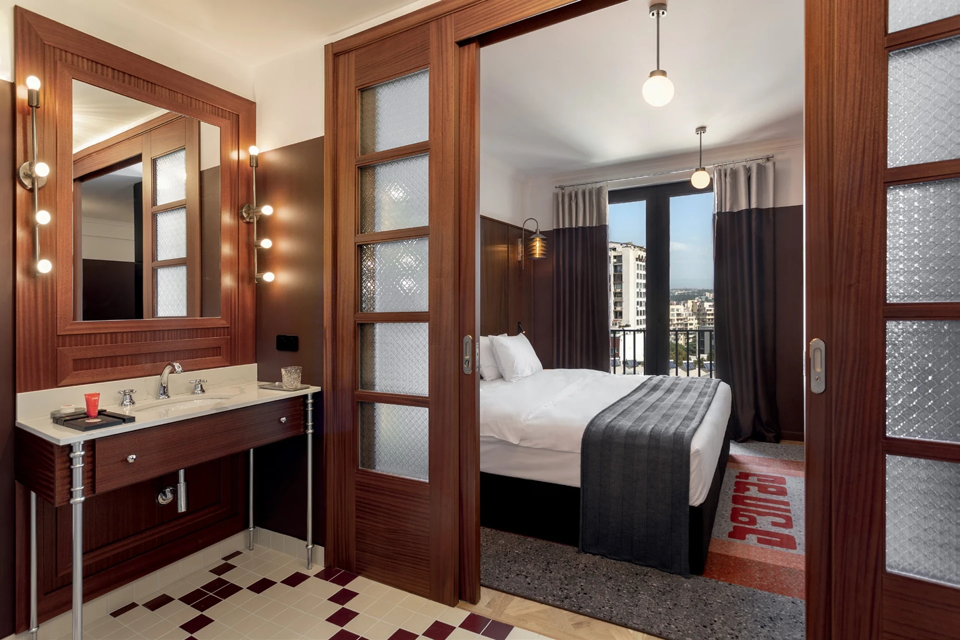 Camera con pavimento a scacchi in stile vintage, porta scorrevole e letto matrimoniale. Afisha Hotel 5 stelle, Tbilisi, Georgia. Arredamento su misura Tomasella Contract, 2024.