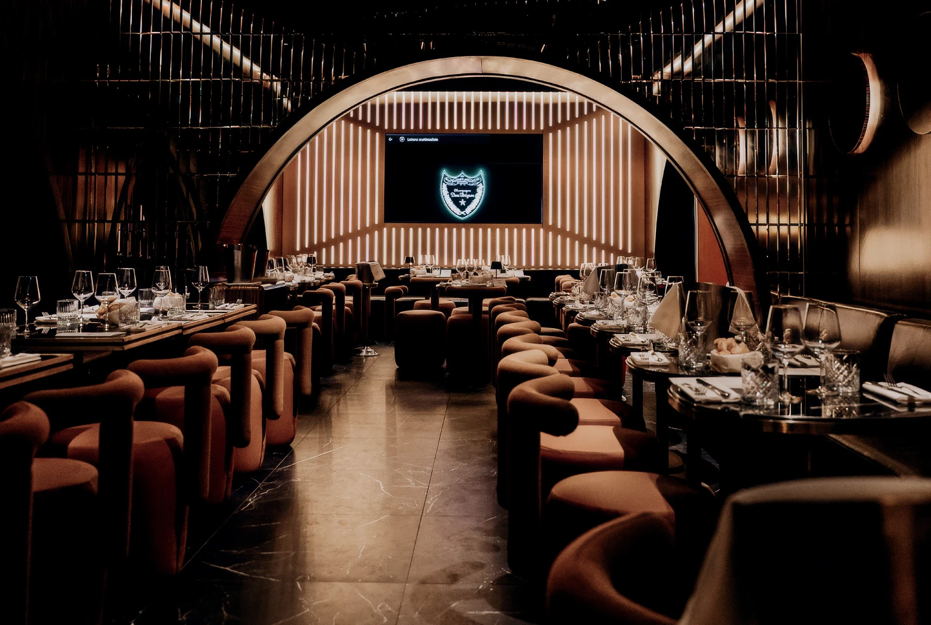 Vista completa della sala ristorante con sedute in velluto, tavoli e palco centrale illuminato. Colle Bereto, Firenze. Arredamento su misura Tomasella Contract, 2025.