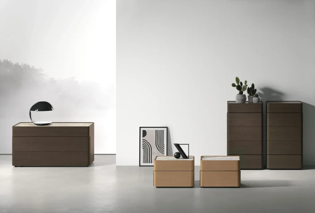 Linea Brando di Tomasella Contract: comò in Rovere Moka con top in gres Taj Mahal, comodini in Rovere Cognac con Calacatta Oro, settimanali con Stone Emperador. Design curvo vintage 2024.