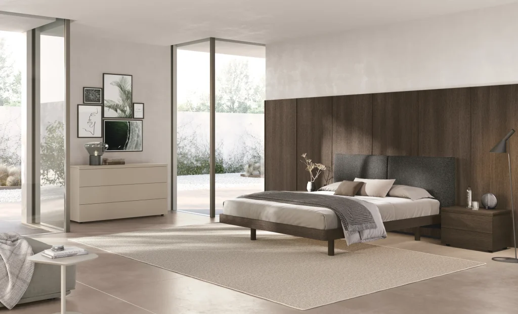 Letto Dhara Ring 100 Tomasella Contract in Rovere Moka e tessuto Saturno Fumo, abbinato alla boiserie Kumi e al contenitore Cooper. Camera da letto intima 2024.