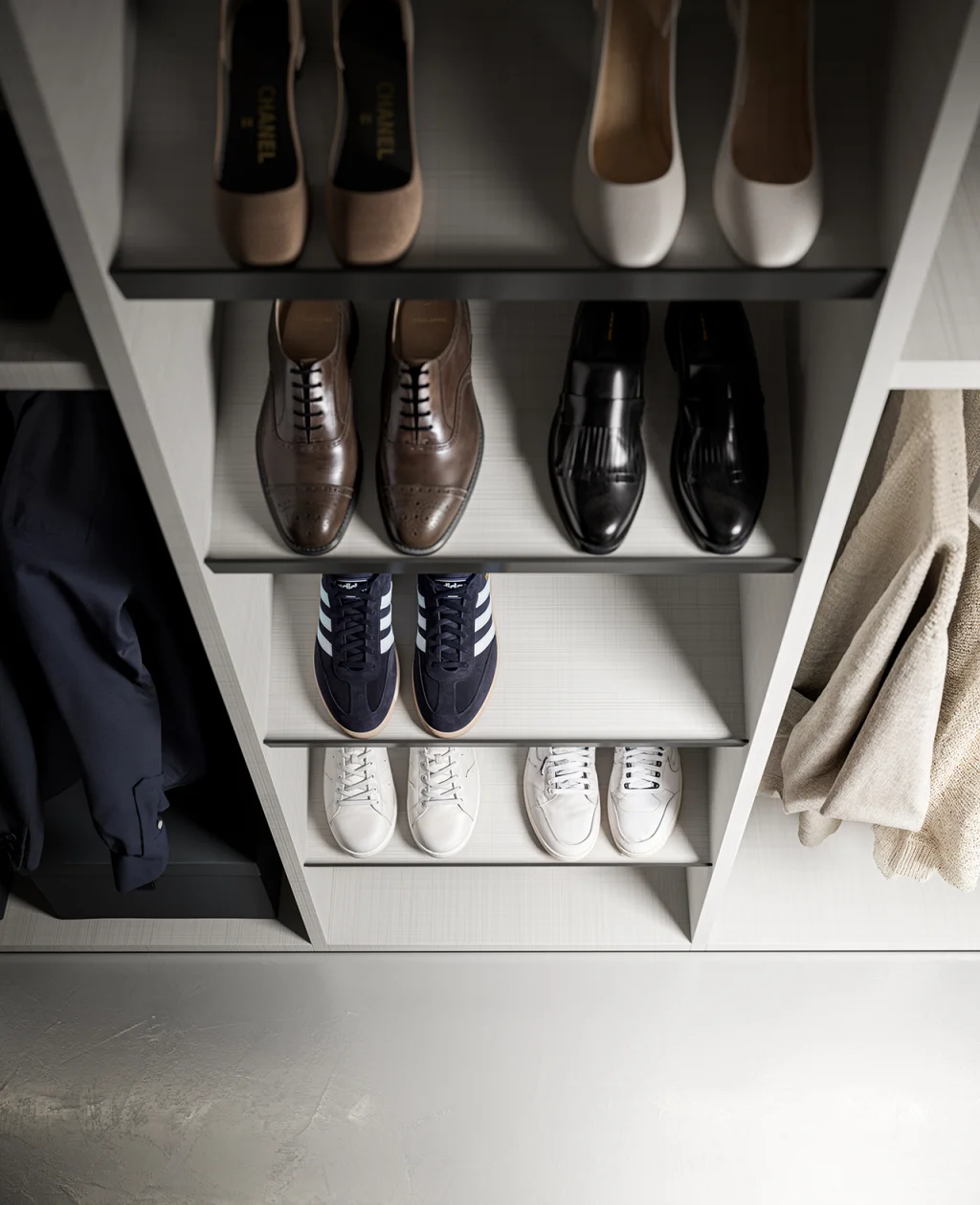 Dettaglio della cabina armadio Prime Tomasella: mensole portascarpe in finitura chiara con calzature eleganti e sneakers.